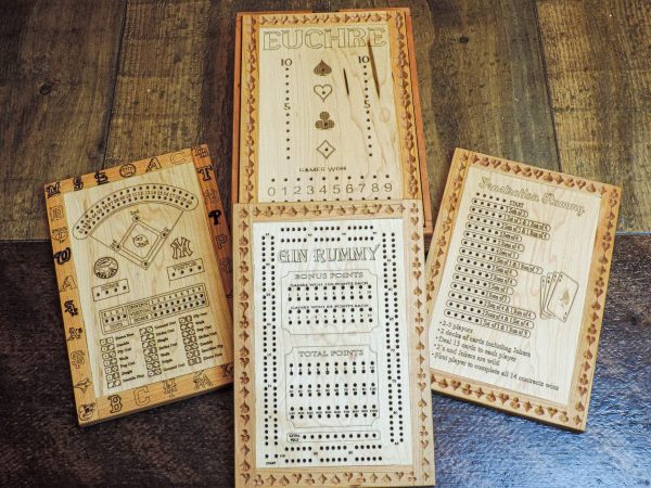 Handcrafted wooden board game showcasing a variety of scorecards layed out on a harvest table. Canadian-made by Bergeron Woodgrains