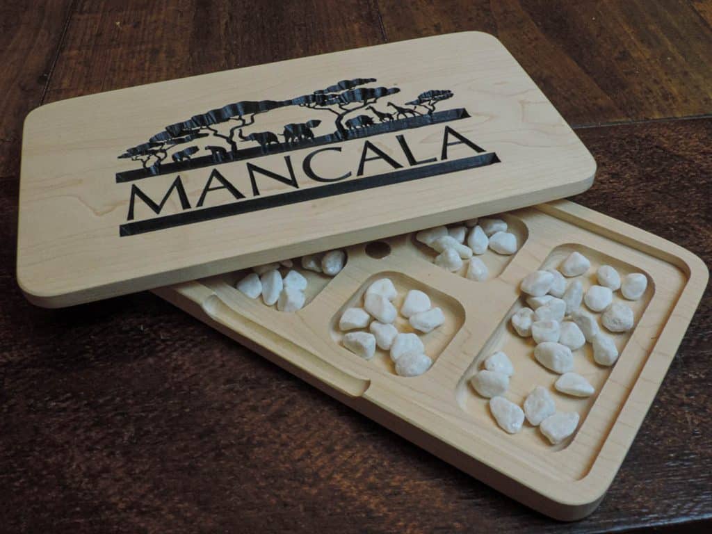 Beautifully crafted Mancala board game using Canadian Maple, stone pieces and embedded magnetic closures. Convenient design and compact storage, made by Bergeron Woodgrains.