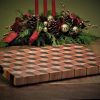 Handcrafted 12x18" 3D tumbling block end grain cutting board resting slightly elevated on a harvest table made by Bergeron Woodgrains