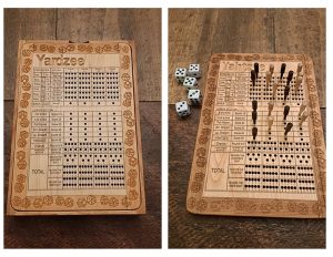 Handcrafted wooden board game featuring a Yardzee scorecard with storage box for accessories next to a Yardzee wood score card with pegs and dice displayed. Made by Bergeron Woodgrains.