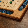 Handcrafted wood sequence board game featuring a cherry border with game piece cutouts and laser engraved baltic birch centre. Canadian made by Bergeron Bergeron