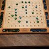 Handcrafted wood sequence board game featuring a cherry border with game piece cutouts and laser engraved baltic birch centre. Canadian made by Bergeron Bergeron