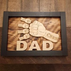 Handcrafted wooden home decor sign made by Bergeron Woodgrains. Black painted frame with natural wood name label such as Dad with matching big fist bump surrounded by smaller fist bumps with matching children’s names all on a flame torched wood background.