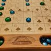 Handcrafted wood sequence board game featuring a cherry border with game piece cutouts and laser engraved baltic birch centre. Canadian made by Bergeron Bergeron