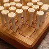 Wood square traditional peg solitaire brain teaser featuring guidelines for legal moves, bevelled edges, wooden pegs and scoring instructions on the back. Made in Canada by Bergeron Woodgrains