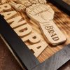 Handcrafted wooden home decor sign made by Bergeron Woodgrains. Black painted frame with natural wood name label such as Grandpa with matching big fist bump surrounded by smaller fist bumps with matching children’s names all on a flame torched wood background.