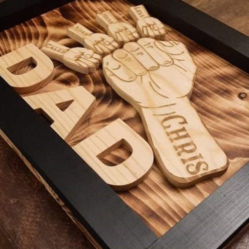 Handcrafted wooden home decor sign made by Bergeron Woodgrains. Black painted frame with natural wood name label such as Dad with matching big fist bump surrounded by smaller fist bumps with matching children’s names all on a flame torched wood background.